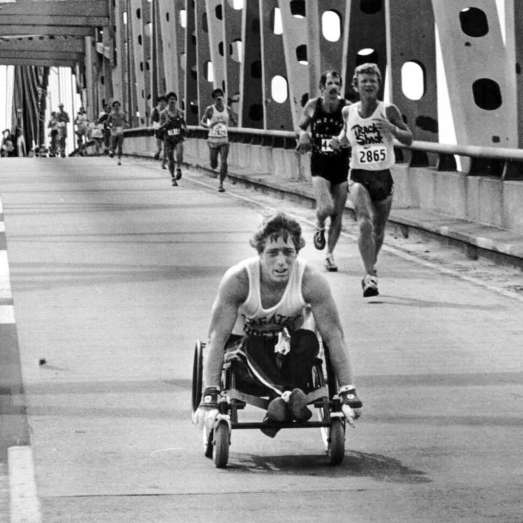 Bob Hall competing in a wheelchair alongside runners during the New York City Marathon in the 1970s.